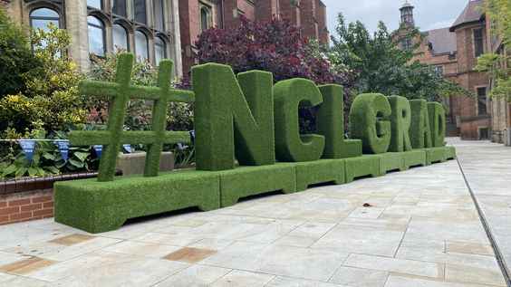 Custom artificial grass signage displayed at a Perth event.